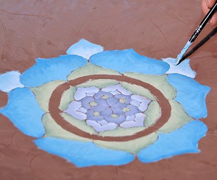 3 Continue painting the design, working your way outward, and selecting colors to differentiate each concentric ring of petals.