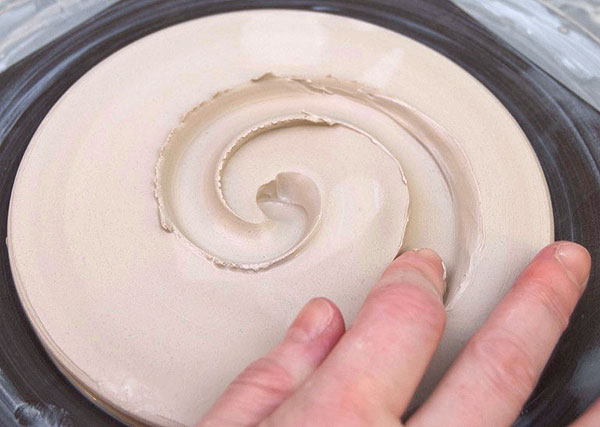 1 Draw your finger outward as the wheel turns to create a spiral in the base.