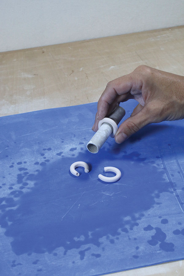 11 Roll thin coils of clay to make small handles. Wrap the coils around a cylinder to create a nice arch in the handles.