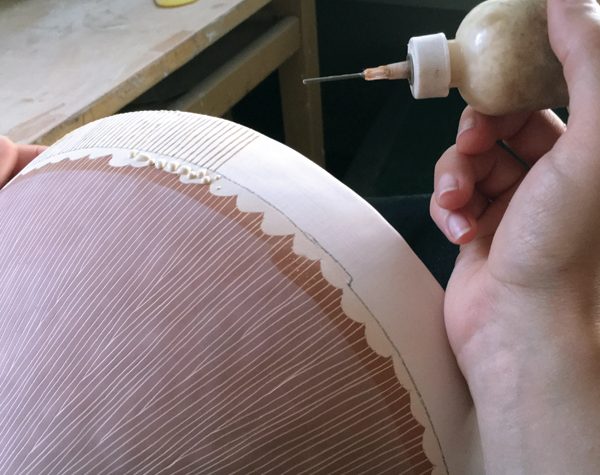 5 Trail undiluted wax lines onto the rim of the bisqued bowl prior to glazing to create a resist pattern.