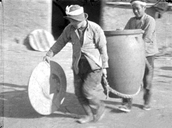 3 Carrying a large storage jar at the workshop of Kumagoro Sumi, Fukuoka, Japan, 1934. From Bernard Leach Films Mashiko & Other Pottery Villages, 1934.