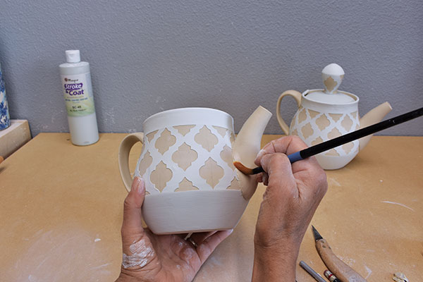 10 Clean up the seam. Don’t remove any glaze decoration on the body of the pot.