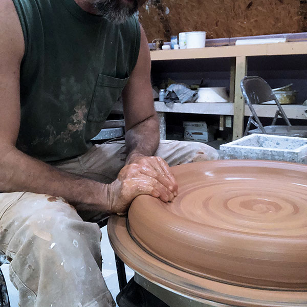 1 Center and open a 30-pound piece of clay close to the edge of a large bat.