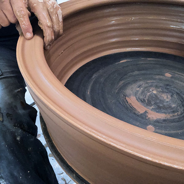 6 Throw a 30-pound ring of clay into a thick-walled cylinder that is the same diameter as the plate rim and create a groove in the rim.