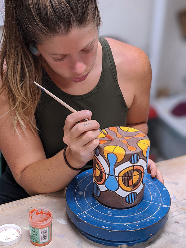 8 Erika Novak adding underglaze colors to a carved, lidded box.