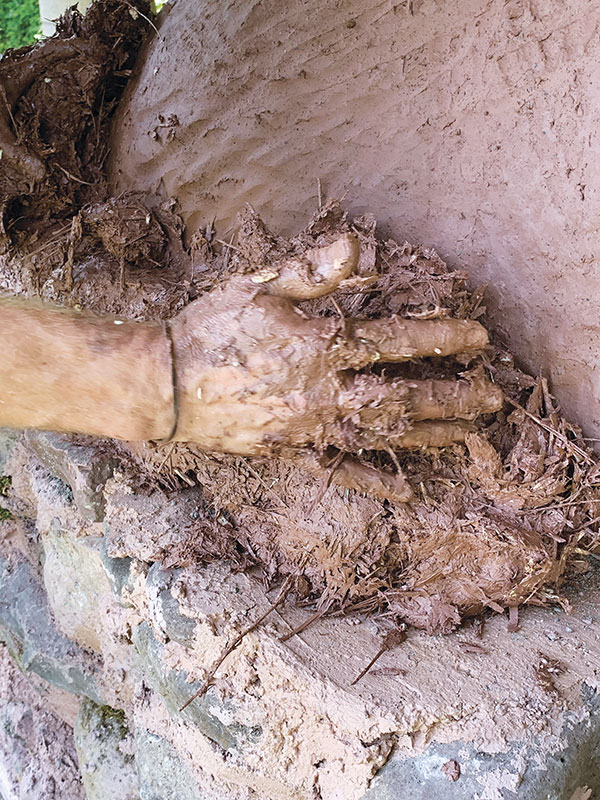 15. Pack the outer insulation of clay slurry, sawdust, and straw onto the dome.