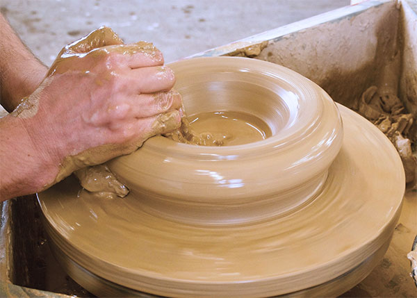 1 After centering, open the ball of clay and throw up and outward keeping the roll of clay contained by both hands.