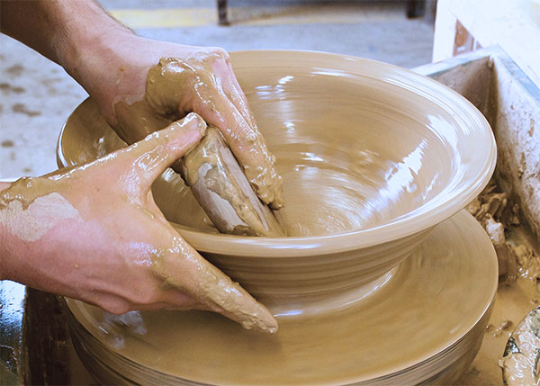 3 Maintain support of the clay wall with your outside hand while opening with a rib.