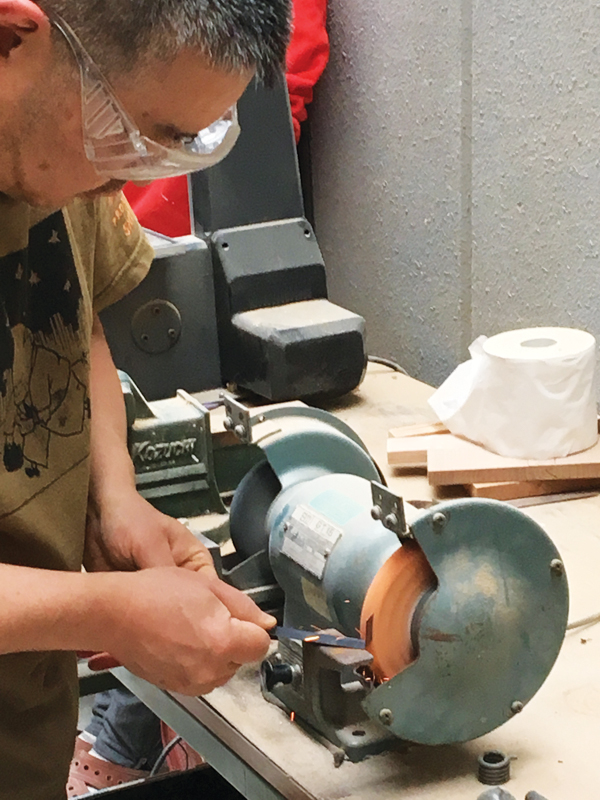 3 Using a grinder to trim down the previously drawn-on shaded area of the kana.