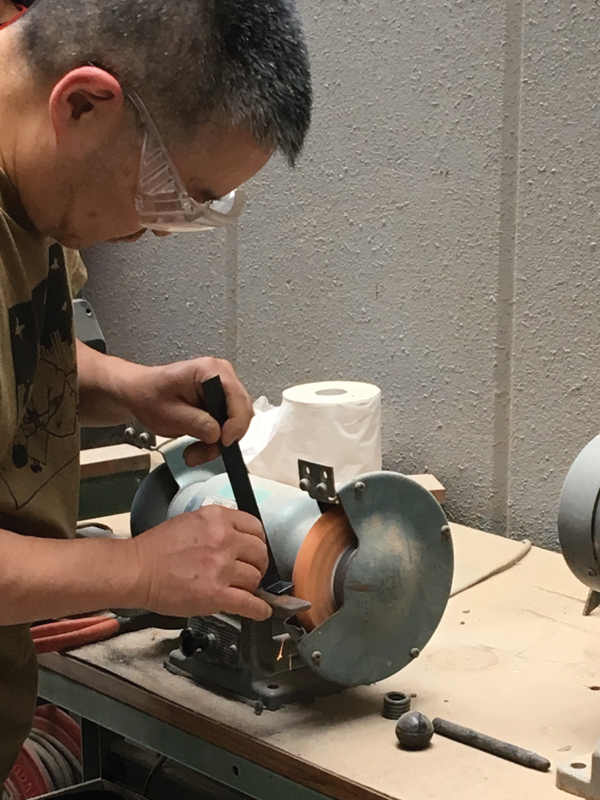 4 Using a grinder to trim down the previously drawn-on shaded area of the kana.