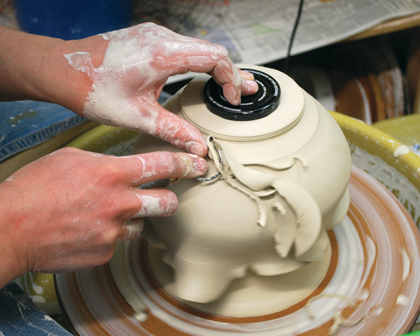 6 Bring the spout out to 45° with your right index finger while supporting with your left hand. Trim the batter bowl on a chuck.