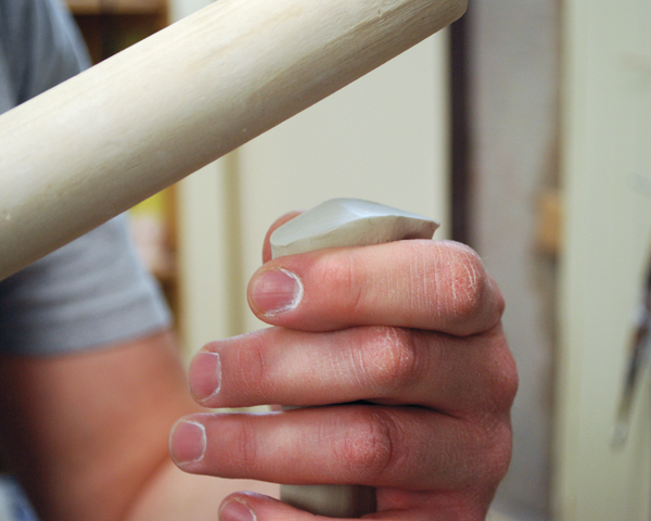 8 Use a dowel as a paddle to shape the upper handle attachment.