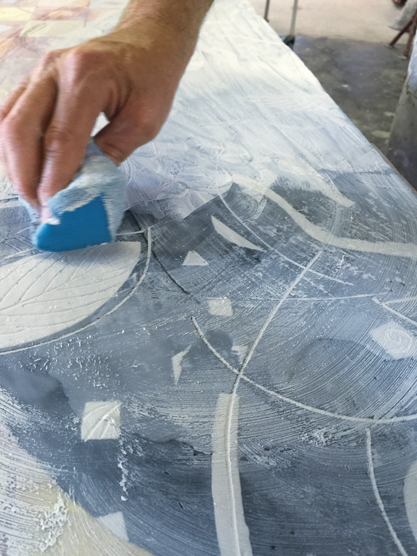 18 Excess slip is wiped off the wax surface allowing it to stay in the cracks in a sgraffito manner.
