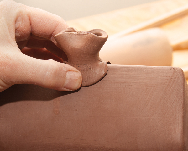 10 Join the knob to the ridge line, creating a  decorative attachment with deep finger marks that’s ready to be sculpted.