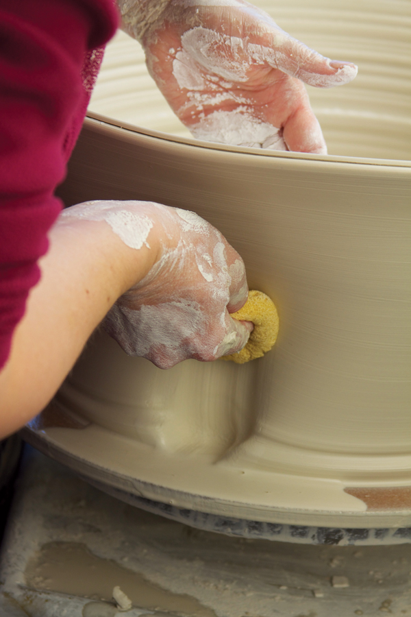 6 Using a thick throwing sponge, begin to push in and up from the outside of the cylinder.