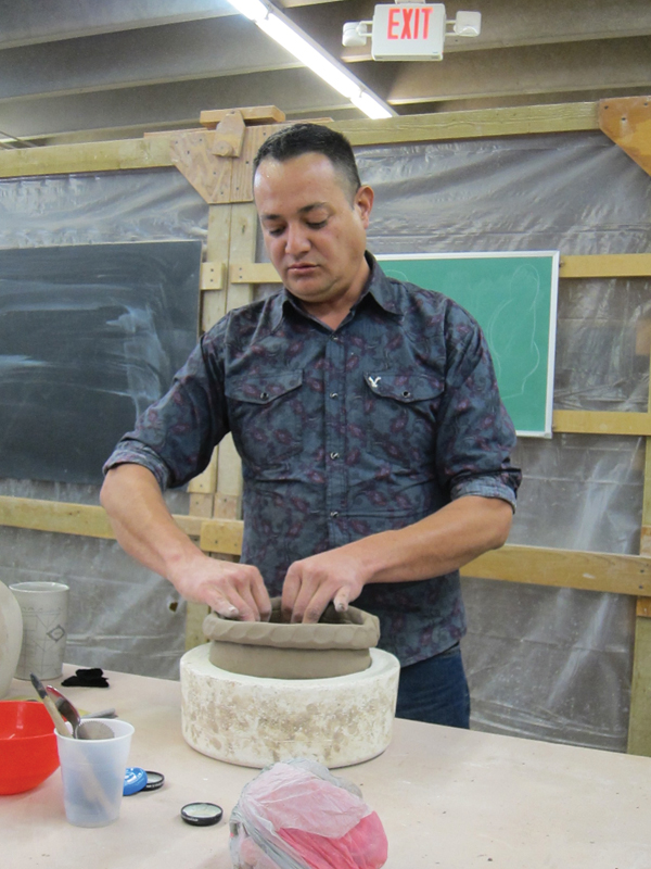 1 Eli places a large, round piece of clay into a plaster puki, pinches up the walls, then adds a coil to begin building up his pinch pot.