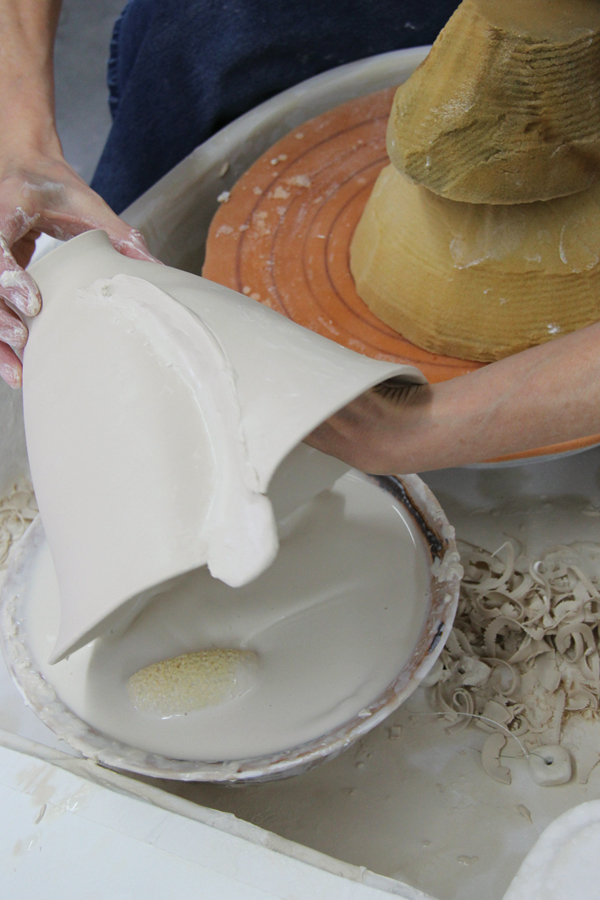 4 Quickly dunk the pot in a bucket of throwing water deflocculated with a few drops of vinegar to soak water back into the walls. Dunk one side at a time, even if altering both sides. Dry off any excess water puddles to prevent weak spots.