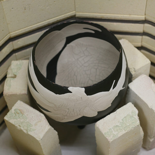 2 Build a barricade as tall as the pot to protect the kiln from possible glaze pop offs, then fire the piece.