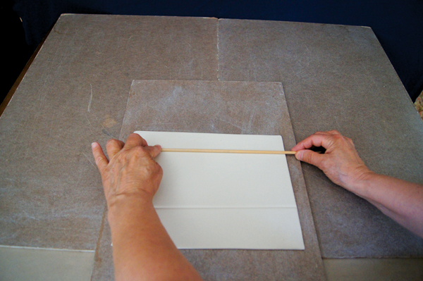 2 Use a dowel to create a line above and below where you want to cut slits.
