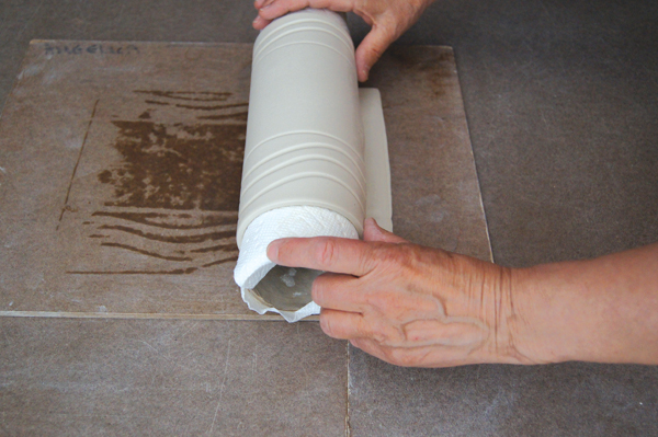 4 Roll the rectangular clay piece around the paper-lined tube.