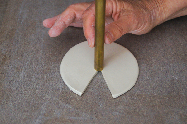 6 Use a ¼–½-inch piece of metal tubing to punch a hole in the center of the circle.