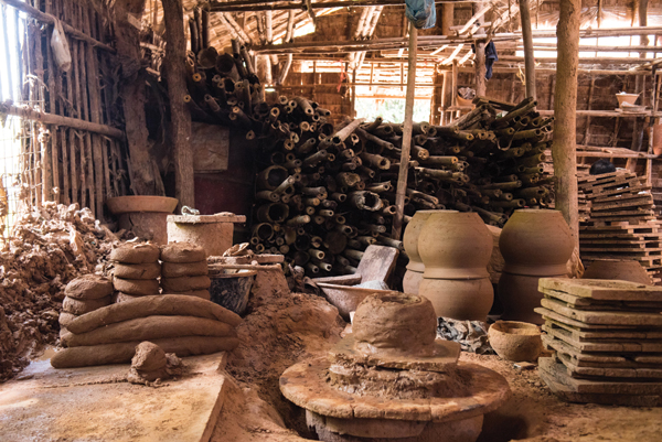 2 This is the wood storage area for Twante’s brick kilns, shown with drying pots and pugs of clay next to a potter’s wheel in the foreground.