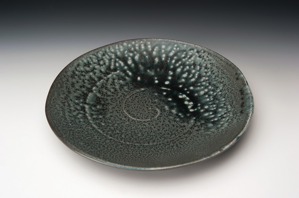 7 Plate, 10½ in. (27 cm) in diameter, jigger/jollied porcelain with matte black and ash glaze, reduction fired to 2372°F (1300°C). Photo: Steve Cummings.