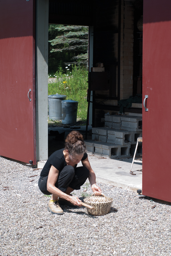 12 Sikora gently tapping the side of a casserole to release a lid after the glaze firing.