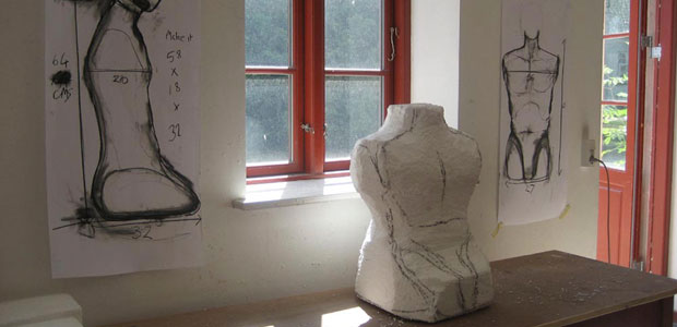 Christie Brown carves styrofoam into various shapes, like this torso. Later she will use these shapes to create plaster molds for press molding.