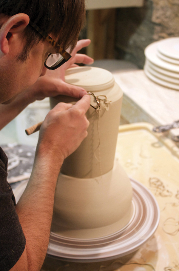 4 Trim the leather-hard pitcher on a leather-hard chuck. Use a rib to form and refine the shape of the foot.