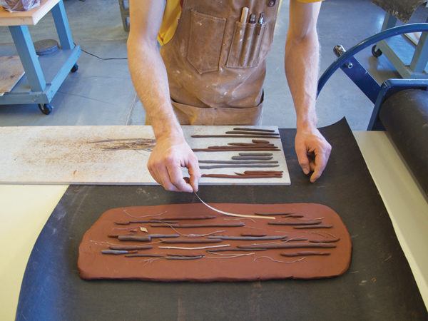 Add organic materials and clay coils to another slab, which will form the top of the tray.