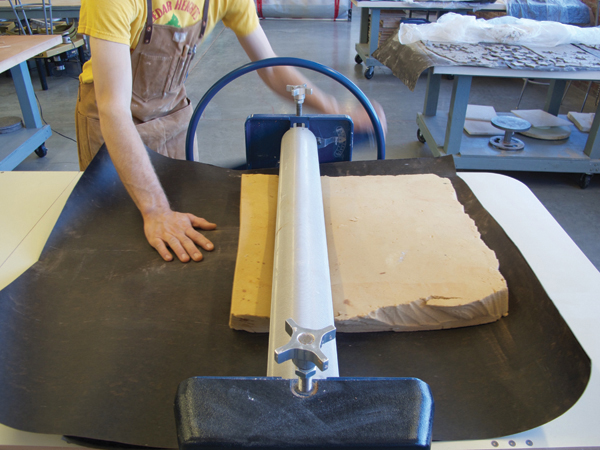 Sandwich the slab between tarpaper and a thick piece of foam, then roll it through the slab roller to compress it.