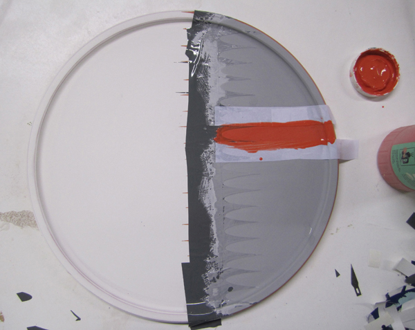 5 Meredith brushes on 2–3 coats of gray underglaze, allows them to dry, then adds orange underglaze.