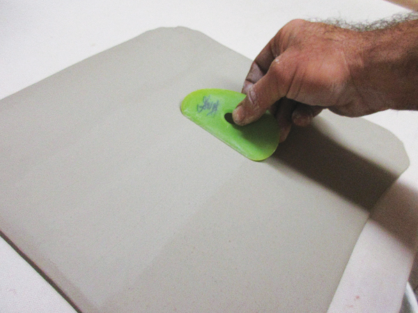 3 Use a plastic rib to compress a slab to prevent warping and cracking, and to remove any canvas texture.