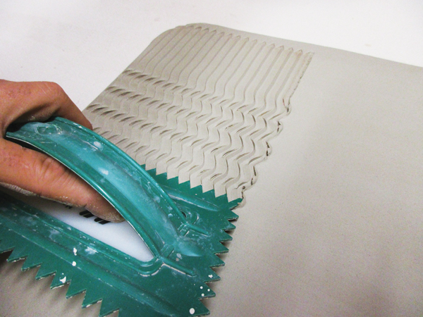 5 Create contrast on the slab by pulling a wide-line edged plastic trowel across the surface in a wavy pattern.