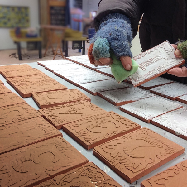 8 Paint underglaze on each tile, allow it to dry, then wipe off in areas with a damp sponge to highlight the texture.
