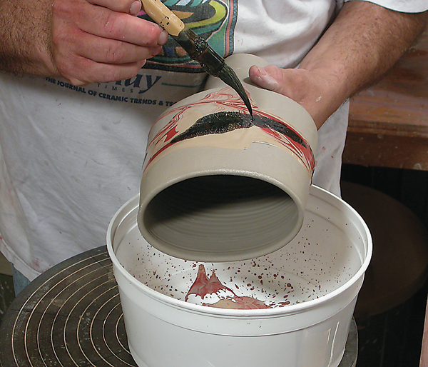 1 Dip, brush, or pour colored slips over the surface of the pot and keep them wet and fluid.