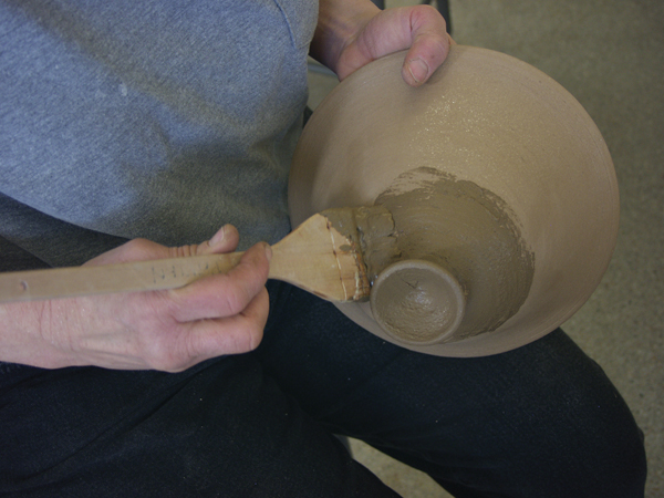 8 Brush a layer of slip onto part of the pot. Don’t worry if it goes on lumpy.