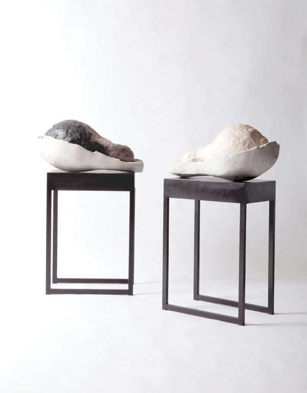 I am a Multiple of Eight (left), I am One in Eight (right) (edition of 8), each 22 in. (56 cm) in height, raku-fired ceramic, cement, acrylic resin, varnish on metal table, 2012. Courtesy of Hauser and Wirth Gallery.