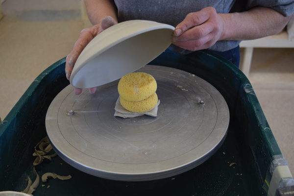 5 Trim the lid to match its interior. Support the center of the lid using dry sponges and pads of clay to add a knob.