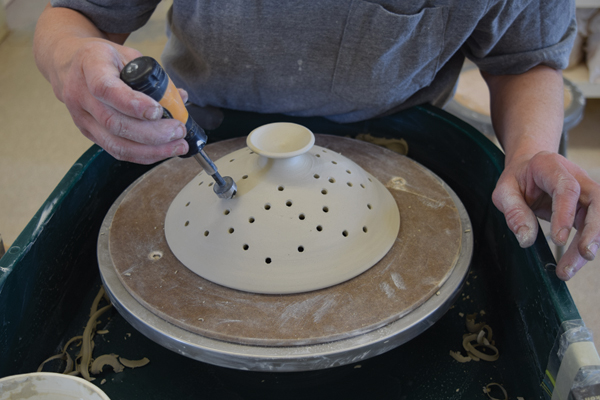 10 Use a countersink drill bit to bevel the edge of each hole inside and out before drying and bisque firing the pot.
