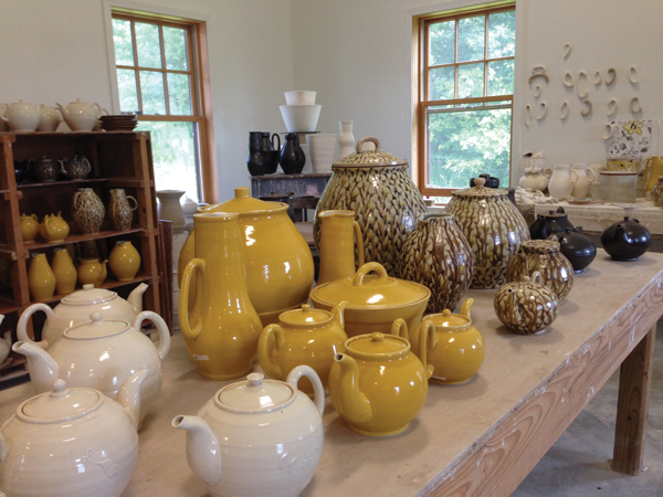 13 Finished pots lined up on a work table in Sikora’s studio.