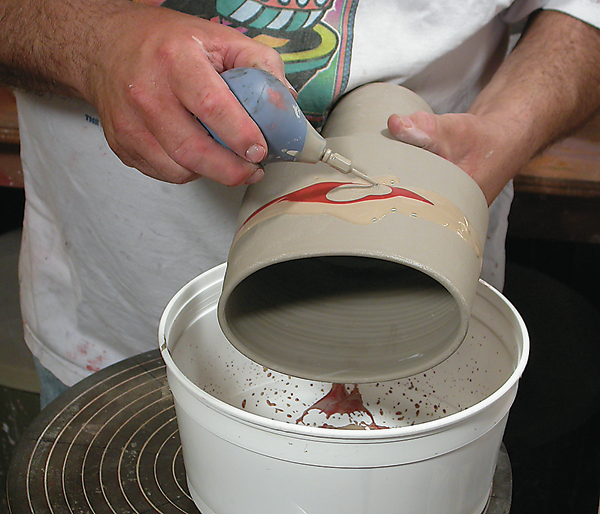 2 Dip, brush, or pour colored slips over the surface of the pot and keep them wet and fluid.