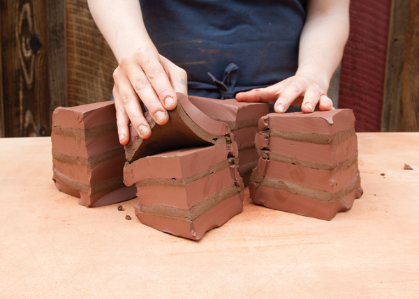 2 Use a wire tool to divide the stacks vertically into a manageable size, then wedge a 5-pound ball of clay.