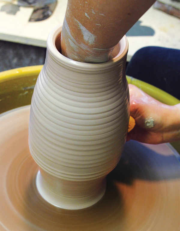 1 Use 3 pounds of clay to throw a cylinder that’s 9–10 inches (23–25 cm) in height, then shape it into a bottle form.