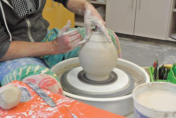 2 Using a porcelain slip instead of water, begin collaring in and rethrowing the top portion to center it.