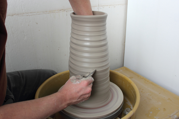 2 Throw a cylinder to the desired height while maintaining a cone shape.