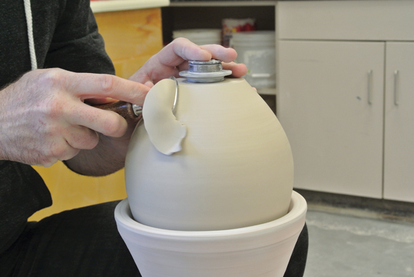 7 Put the pot upside down into a chuck and trim the bottom to make for an easier fit with a glaze catcher.