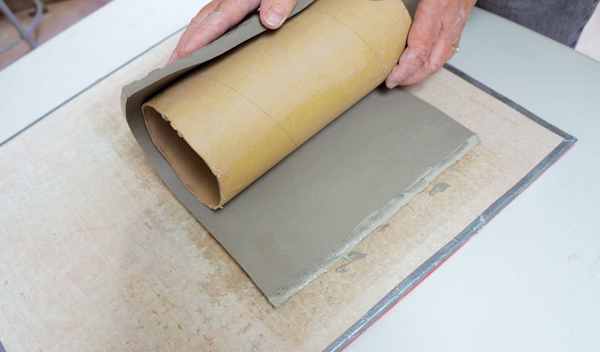 2 After scoring and slipping both beveled sides of the template, gently wrap it around the cardboard tube.