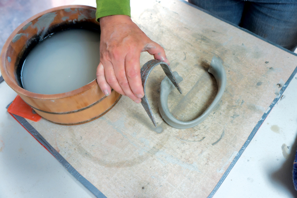 11 Paint an ‘L’ shape with water onto a ware board to simulate the pot’s profile, then cut and shape the handle to fit it.